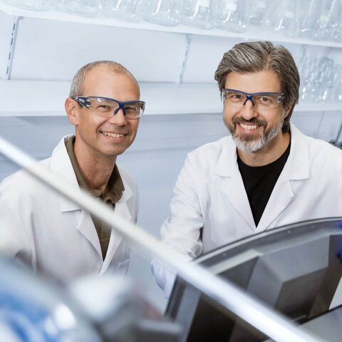 Scientists in a laboratory working with advanced bioprocess equipment at VALIDOGEN.