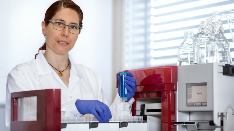 Scientist in a lab coat working with a chromatography system for downstream processing at VALIDOGEN.